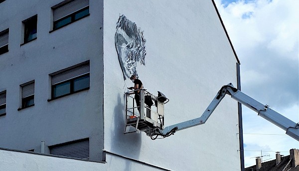 Hendrik Beikirch beginnt seine Arbeit an der Neunkircher Hauswand. Foto: Erik Hoffmann